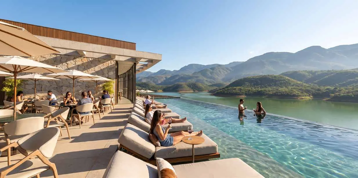 Piscina de borda infinita dos apartamentos boutique com vista para a represa